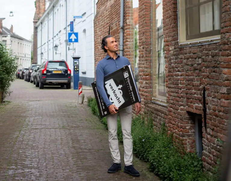 Makelaar Frank Haze met een makelaarsbord